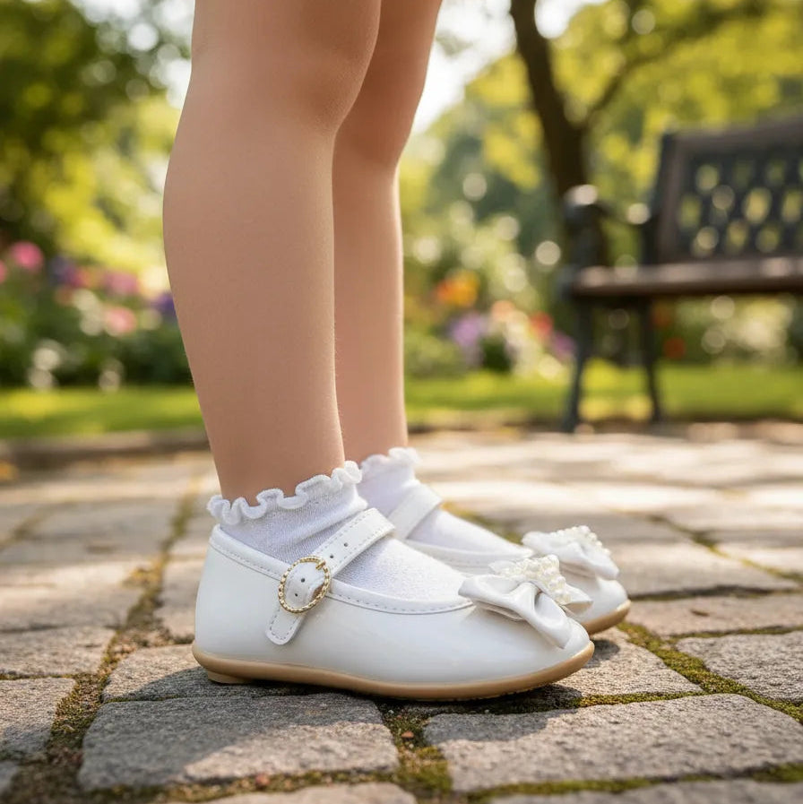 Sapatilha Pimpolho Verniz Branco com Laço e Pérolas – Elegância para os Primeiros Passos